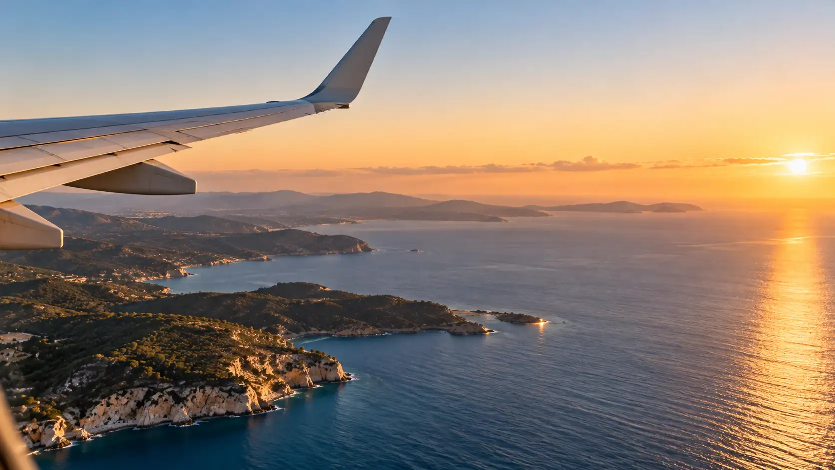 Blick aus dem Flugzeugfenster auf das Meer im Morgenlicht, mit Tragfläche